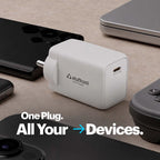 A white plug-in power adapter with the 'stuftool' brand logo, shown on a textured beige surface surrounded by various electronic devices. The text 'One Plug.