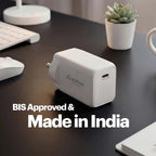 A white Stuftool USB-C power adapter sits on a dark desk with a keyboard, mouse, small potted succulent, and mug in the background. Large white text on the image reads 'BIS Approved & Made in India'.