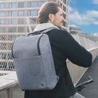 Man wearing a gray backpack in an urban setting
