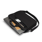 Black laptop bag with a shoulder strap, containing a laptop and a phone, on a white background.