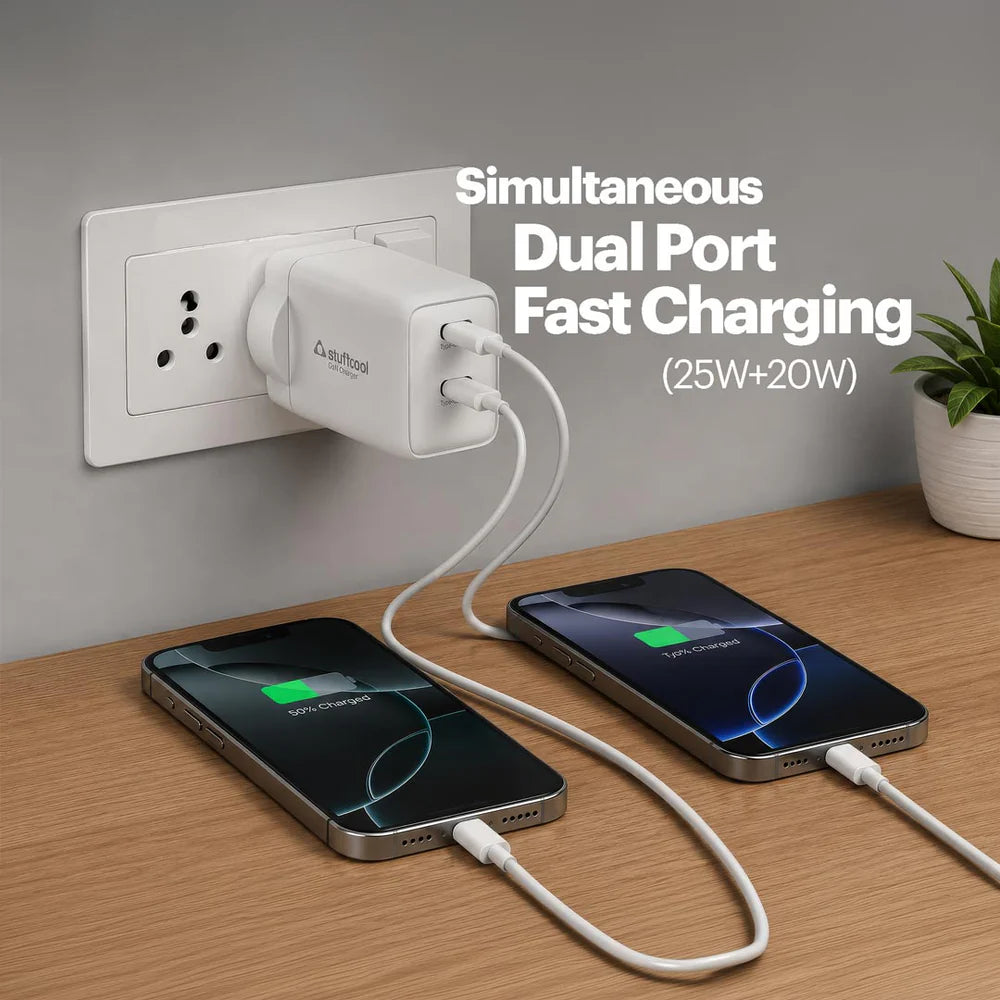 White dual-port charger with two devices being charged on a wooden surface.