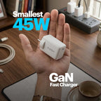 Hand holding a small 45W GaN fast charger with visible brand logo on a desk background.